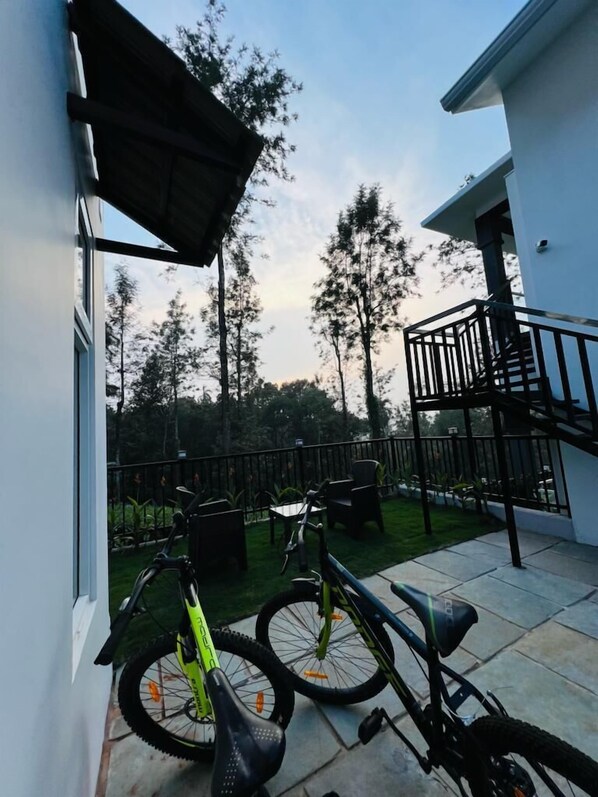 Ein modernes Gebäude mit Balkon, Treppe und zwei draußen abgestellten Fahrrädern.