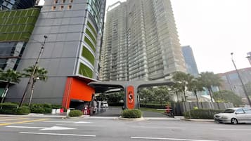 A modern urban street with high-rise buildings, a prominent orange structure, and a clear road with directional arrows.