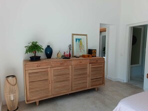 A wooden cabinet with multiple drawers and a small plant on top.