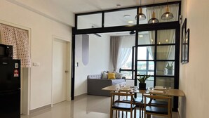 A modern kitchen with a dining area, a refrigerator, a sofa, and a large window with curtains. - Kajang MKH Boulevard Apartments (Kajang)