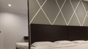 A bedroom with a bed, a nightstand, and a wardrobe.