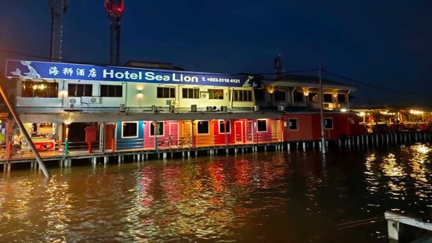 A waterfront hotel with multiple levels, including a ground floor restaurant and upper guest rooms.