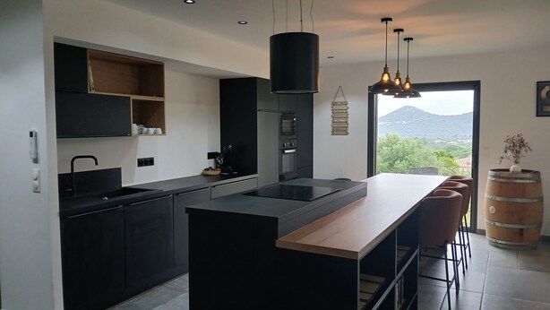 A modern kitchen with a central island, built-in appliances, and a view of the outdoors. - New villa T4 Sotta between land and sea (Sotta)