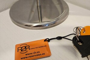 A keychain with a metal key ring and a small orange tag with text.
