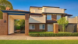 A modern two-story house with a garage, a covered driveway, and a well-maintained lawn.