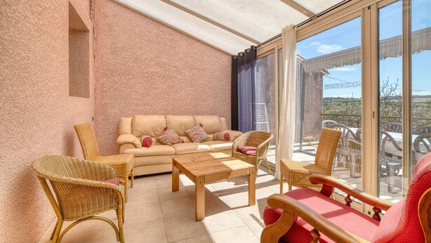 A sunlit room with a sofa, chairs, and a table. - Gîte le lilas - Farm Cottage "la capelle" (La Cassaigne)