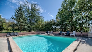 A rectangular pool with clear blue water, surrounded by a concrete deck and lounge chairs. - Gîte le lilas - Farm Cottage "la capelle" (La Cassaigne)