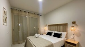 Ein ordentlich eingerichtetes Schlafzimmer mit Bett, Nachttischlampen, einem Nachttisch und einem Fenster mit Vorhängen.
