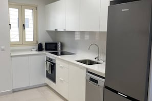 A modern kitchen with white cabinets, a stainless steel refrigerator, a microwave, and a dishwasher. - Playa de Puzol con terraza y piscina (Puçol)