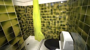 A small bathroom with green-tiled walls, a shower curtain, a toilet, and a hand dryer. - Apartment 4 guests near beach with parking (Argelès-sur-Mer)