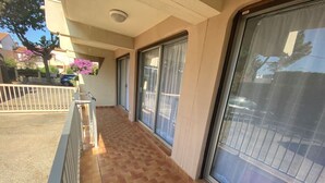 A balcony with a tiled floor, large sliding glass doors, and a white railing. - Apartment 4 guests near beach with parking (Argelès-sur-Mer)