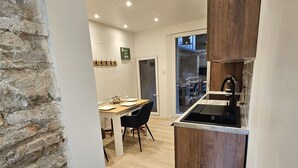 Une cuisine moderne dotée d’une cuisinière intégrée, de meubles en bois et d’un coin repas avec une table et des chaises.