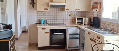 Cocina compacta equipada con lavavajillas, horno, microondas y pileta.