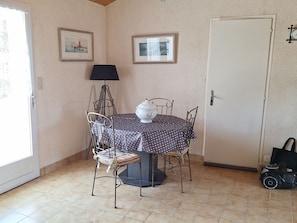 Un espace repas comprenant une table ronde, des chaises, une lampe et une porte.