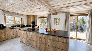 Una cocina moderna con armarios de madera, una isla grande y vistas al exterior.