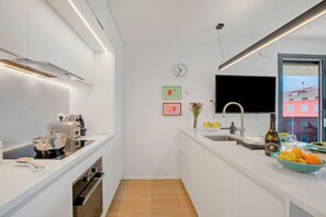 Apartamento família, vários quartos, 2 banheiros (Sole E Lago) | Cozinha privada | Geladeira, micro-ondas, fogão, cooktop