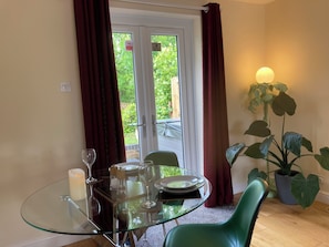 A dining area with a glass table, chairs, plates, and wine glasses.