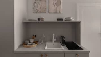 Une cuisine moderne avec un plan de travail blanc, une cuisinière encastrée et un évier. Deux étagères murales sont fixées au-dessus du plan de travail et servent à ranger des bols et un vase.