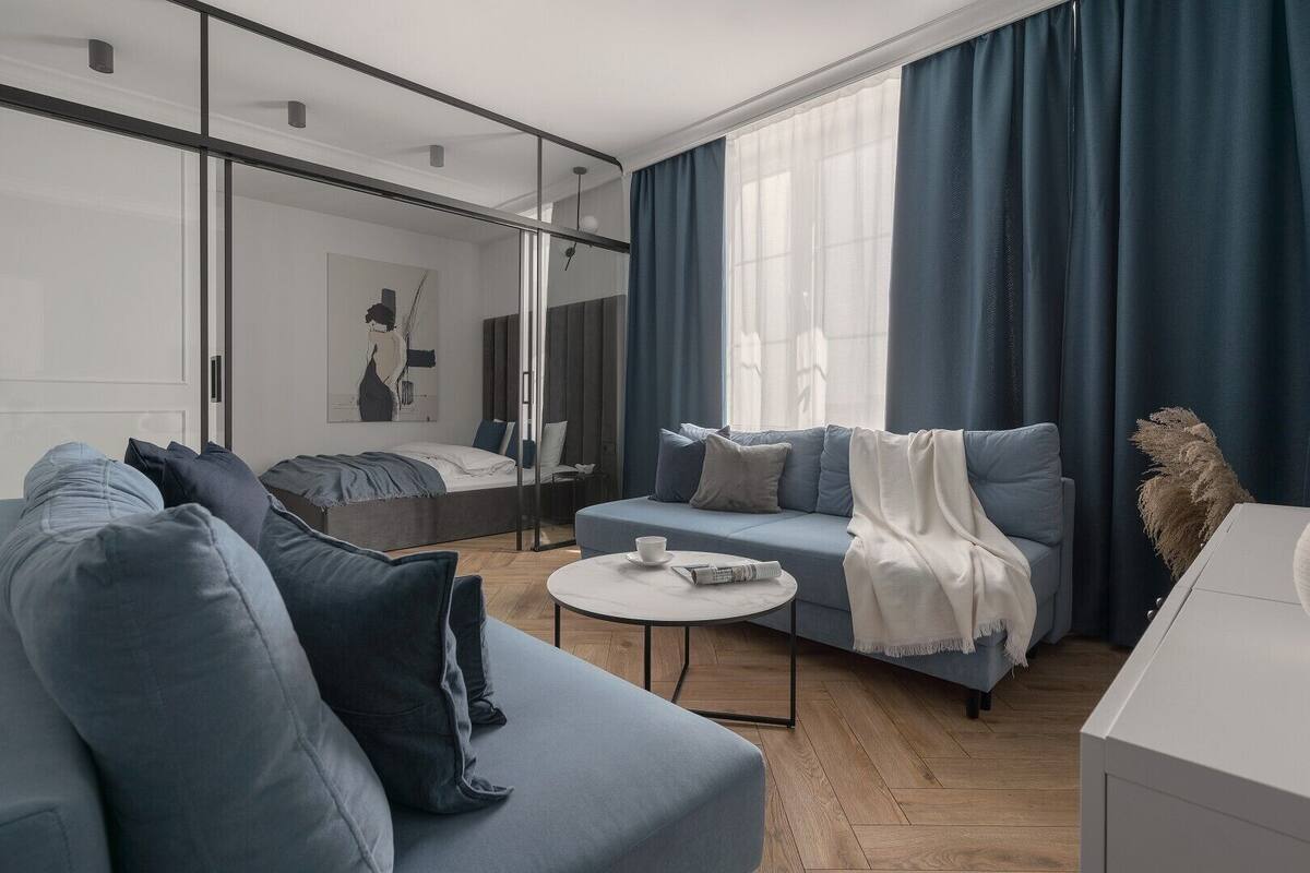 A modern living room with a sofa, a coffee table, and a bed.