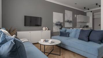 Una sala de estar moderna con un sofá gris, una mesa de centro blanca y obras de arte en las paredes.