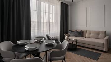 Una sala moderna con comedor, que incluye un sofá, una mesa de centro y una mesa de comedor con platos y tazas.