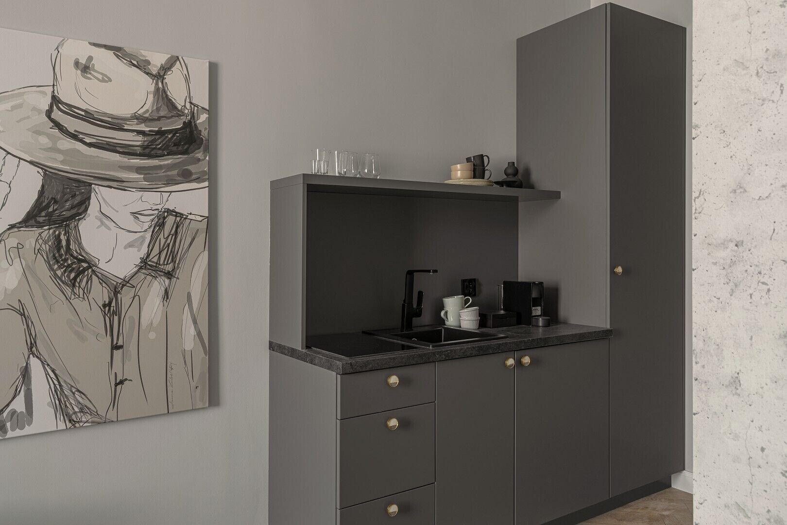 A modern kitchen with a grey cabinet, a coffee machine, and a sink.