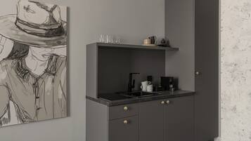 A modern kitchen with a grey cabinet, a coffee machine, and a sink.