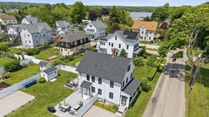 Un barrio residencial con casas, una entrada de vehículos y un césped.