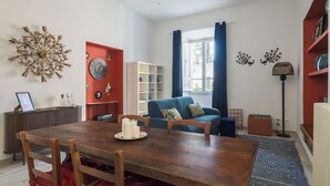 Un coin repas comprenant une table en bois, des chaises, une bibliothèque et un élément décoratif mural.