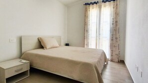 Una camera da letto con un letto, un comodino e delle tende.