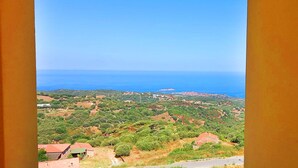 Paesaggio costiero con vista sul mare e edifici sparsi.