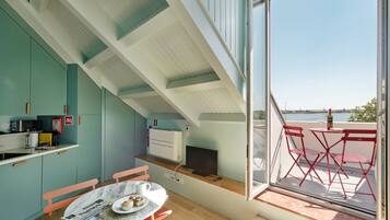 Cocina compacta con comedor, televisor y vista al agua.