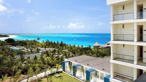 Un hotel de varios pisos con balcones con vista a una playa y al océano.
