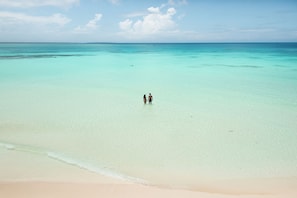 On the beach, white sand, sun-loungers, beach umbrellas