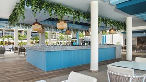 Un espacio interior moderno con una zona de bar central, diferentes disposiciones de asientos y plantas colgantes.