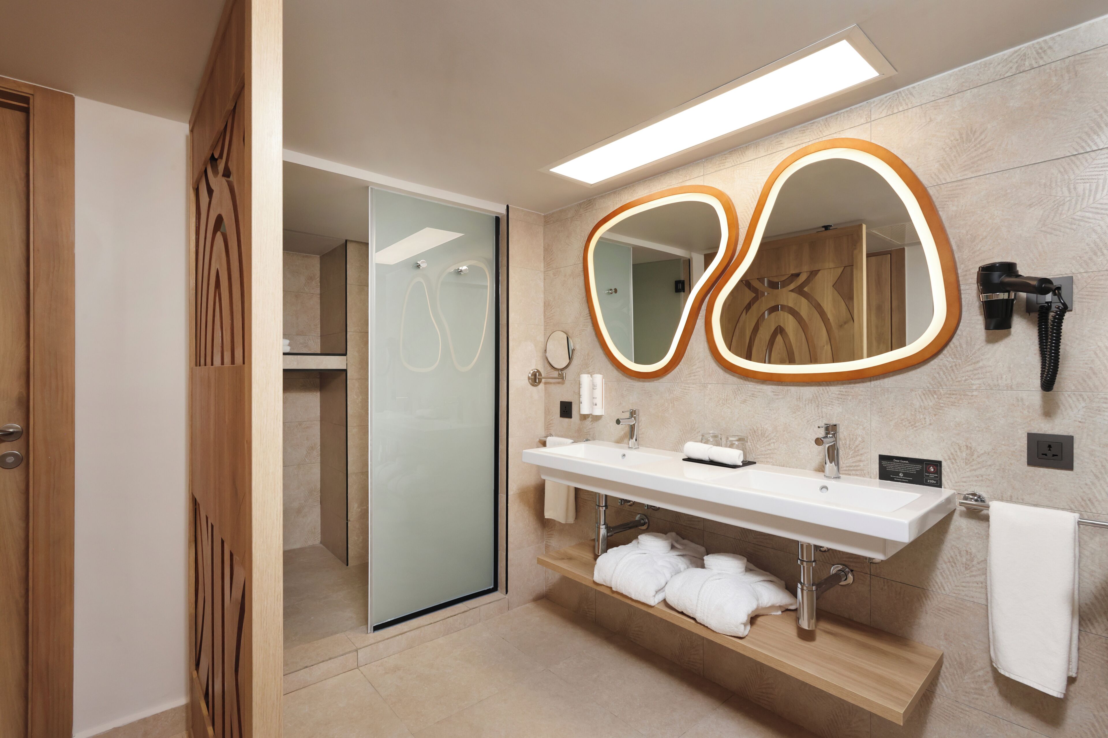 A modern bathroom with a glass shower enclosure, a vanity with a mirror, and a towel rack.