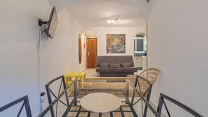 A modern living room with a sofa, a coffee table, and a painting on the wall. - Bright and Spacious 2-Bedroom Apartment Steps from Florida Metro (Red Line). (L'Hospitalet de Llobregat)