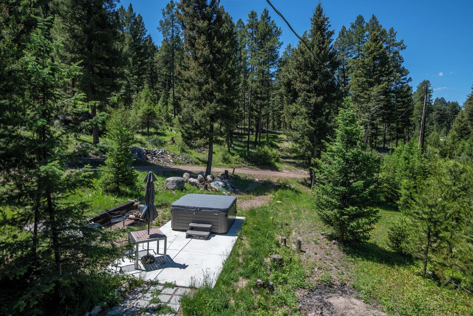Een chalet met terras, omgeven door dicht bos.