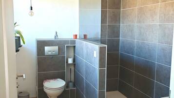 Ein modernes Badezimmer mit Dusche, Toilette und Waschbecken.