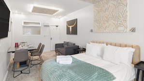 Een moderne hotelkamer met een bed, een bureau en een stoel.
