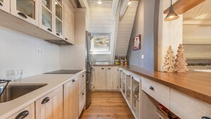 Una cucina con mobili in legno, un lavello in acciaio inox e una finestra con vista sull'esterno.