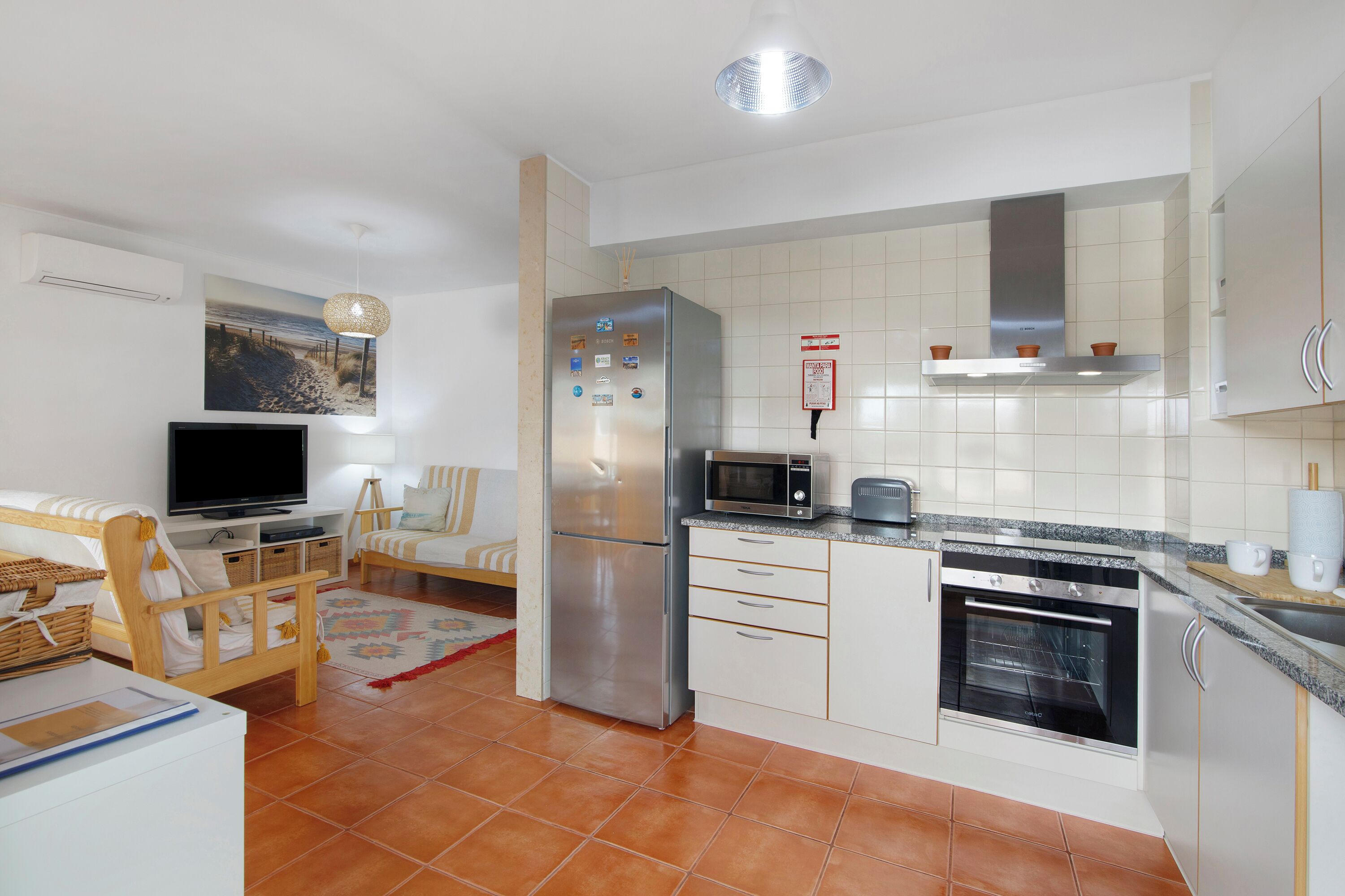 Een koelkast, een magnetron, kookgerei, borden en bestek