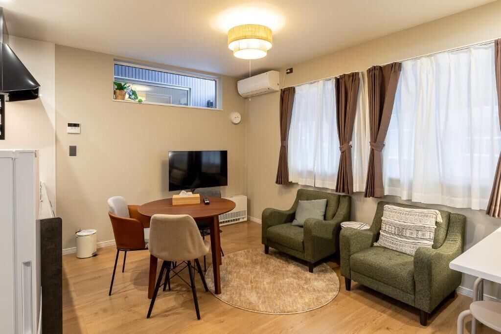 Un saló modern amb televisió, sofà i zona de menjador.