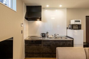 Una cocina compacta con estufa integrada, microondas y fregadero.