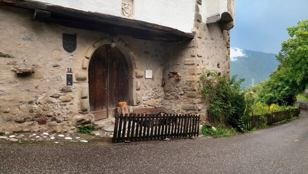 A stone building with a wooden door, a small window, and a stone wall. - Apartment 'Helmsdorf Ritterturm' with Mountain View, Shared Garden and Wi-Fi (Lana)