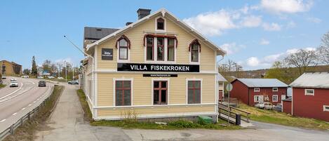 Um edifício de dois andares com uma placa indicando 'VILLA FISKEKROKEN' e um endereço de site.