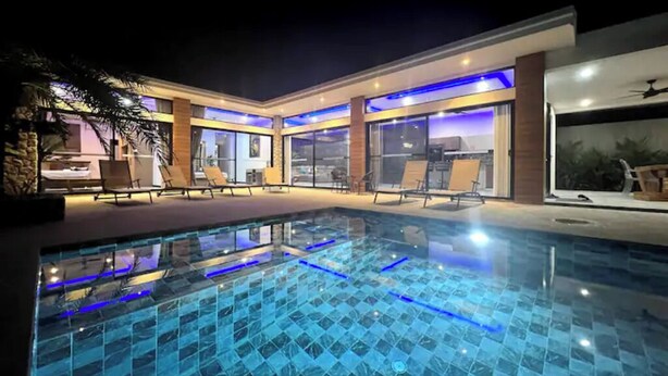 A modern outdoor pool area with lounge chairs and a clear view of the pool.