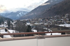 Une ville de montagne avec des bâtiments, un paysage enneigé et une rivière.