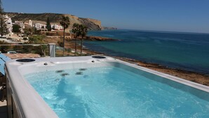A hot tub with a view of the ocean and a coastal town in the background. - Casa do Mar - Luxury Villa w rooftop SwimSpa (Luz)