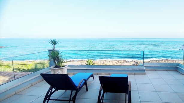 A balcony with two chairs, a potted plant, and a view of the ocean. - Casa do Mar - Luxury Villa w rooftop SwimSpa (Luz)